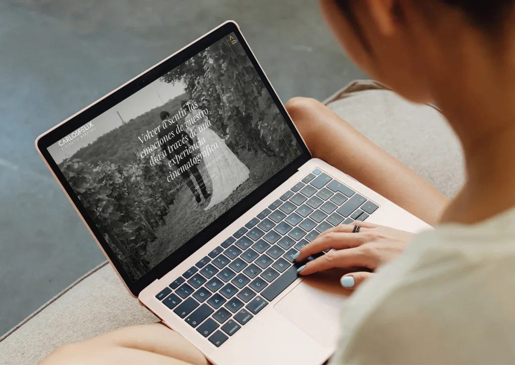 Mujer con portátil mirando la sección de inicio de la web de Carlos Félix Weddings, diseñada por Gala&yo Agencia Creativa